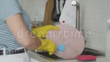 女人的手在厨房水槽里冲洗盘子-用海绵盘子洗涤剂在家里<strong>做家务</strong>。 洗碗